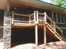 Cedar post deck railing in Matthews, NC, featuring porch railing with cedar log posts, wood railing with cedar newel posts, and a branch handrail complemented by oak boards.