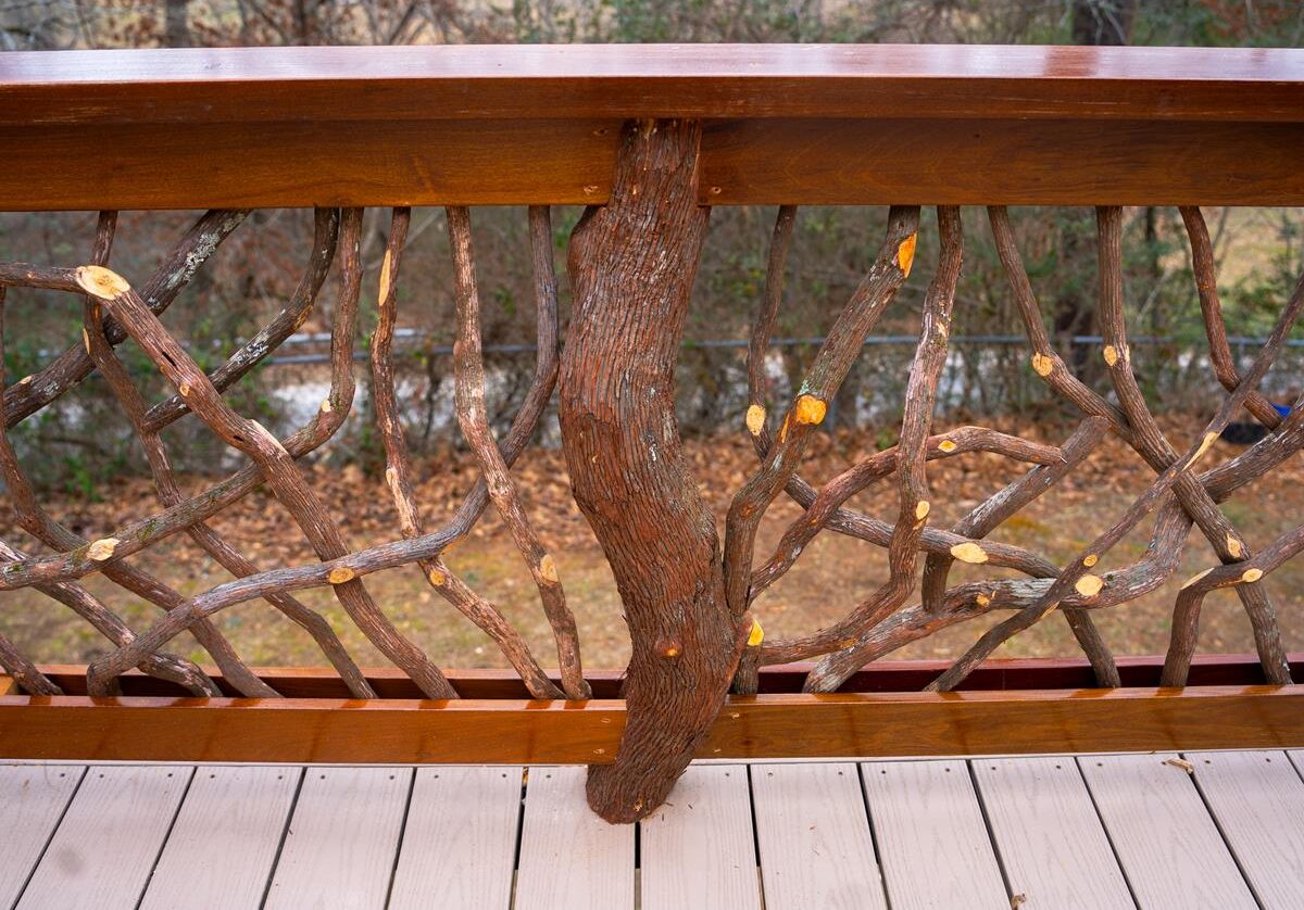 Centered log post integrated within a handrail in Franklin, NC, showcasing rustic design and sturdy construction.