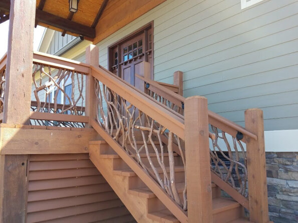 Brown porch stairs featuring mountain laurel branch balusters and sturdy handrails in Elizabethton, TN, creating a welcoming entrance.