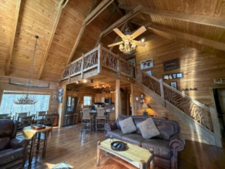 Rustic wooden great room with a loft balcony featuring Mountain Laurel handrails in Gainesville, GA.