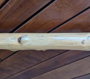 Close-up of a polished locust branch banister showcasing detailed natural grain patterns and a high-gloss finish.