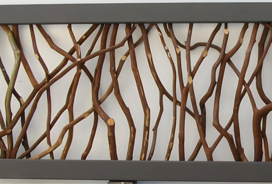Close-up of a woven branch panel featuring natural twigs, framed by dark metal against a light background.