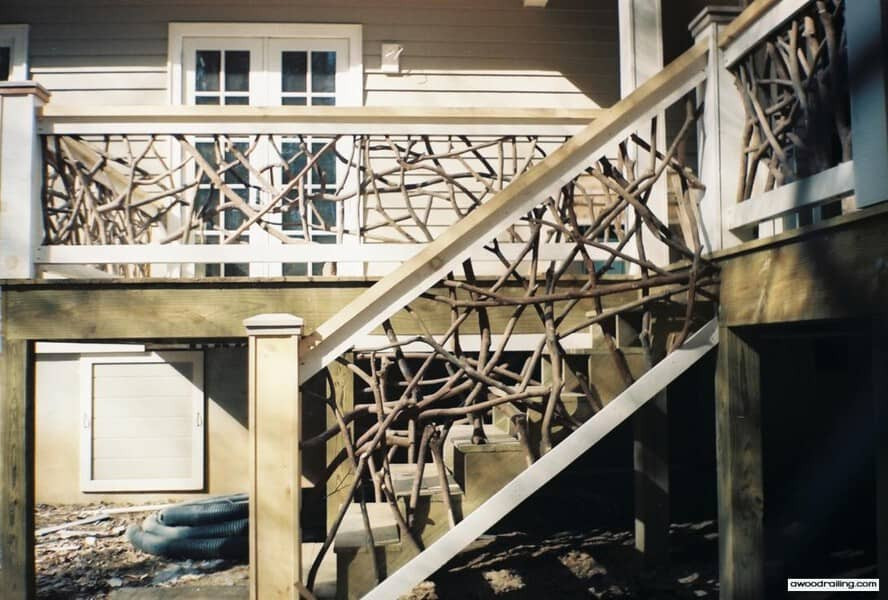 Wooden deck and staircase with dense handcrafted woven branch railings on a house exterior, showing intricate natural twig patterns.