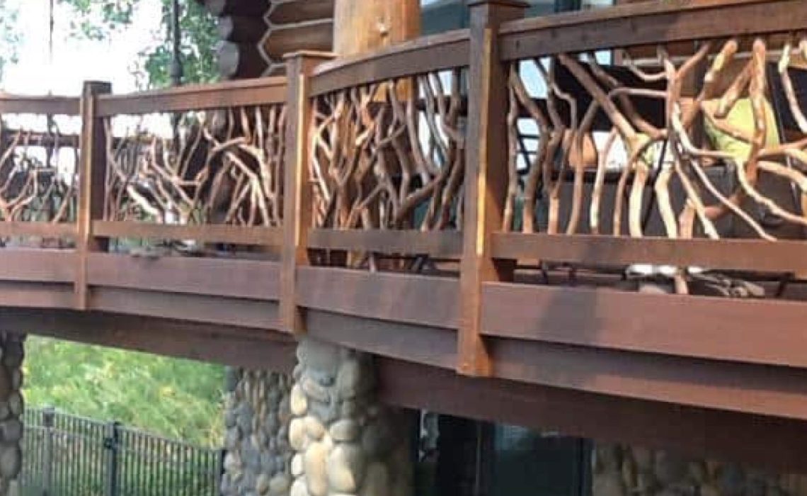 A product photo of curved exterior railings on a large deck, supported by sturdy cobblestone pillars.