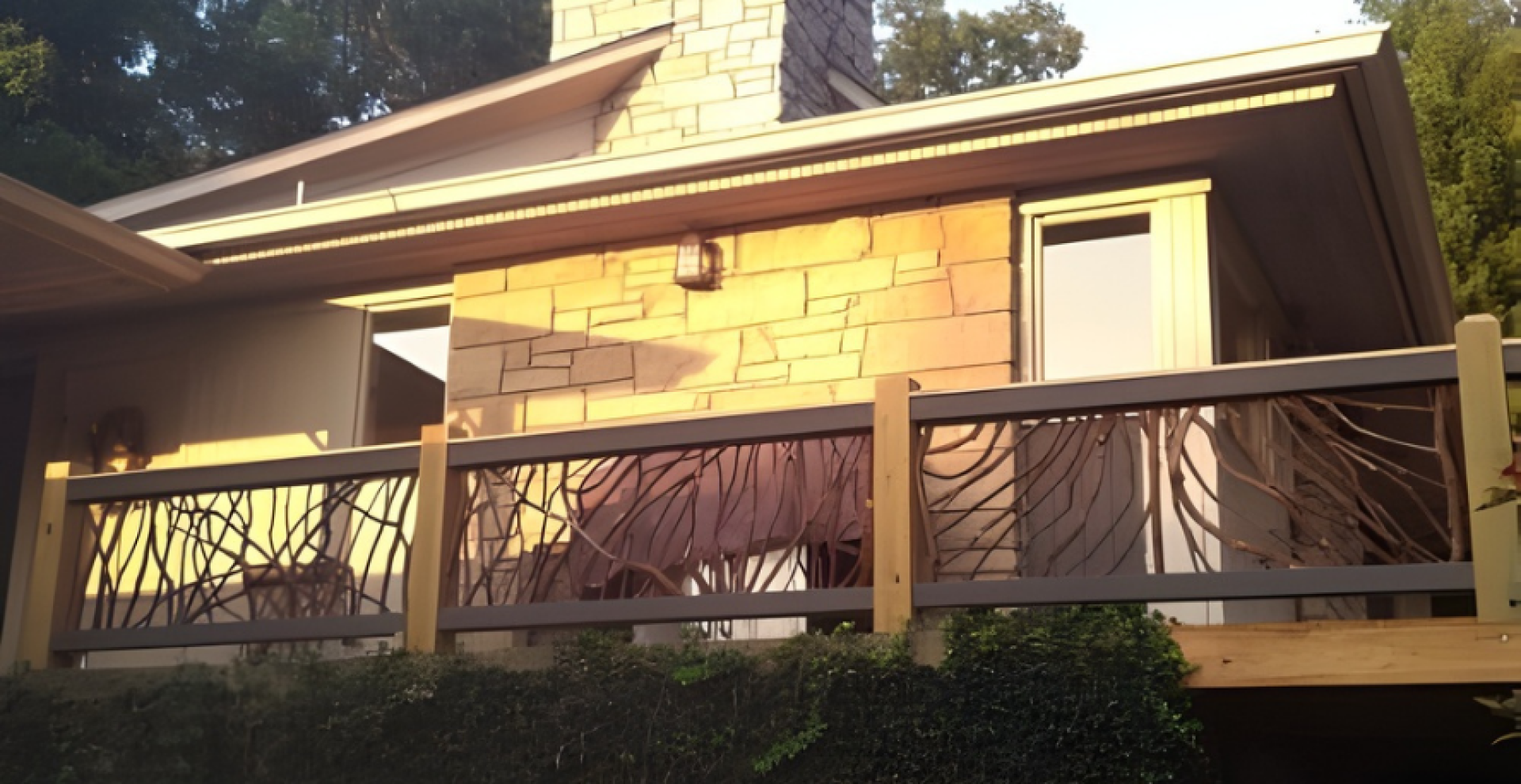 A house with stone and wood exterior featuring a second-floor deck with beautiful handcrafted woven branch railings, surrounded by trees and greenery.