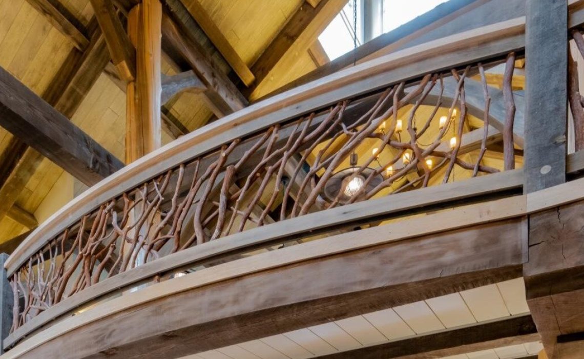 A beautifully crafted curved balcony railing in an interior cabin mansion, highlighting exquisite design and craftsmanship that enhances the luxurious ambiance of the space.
