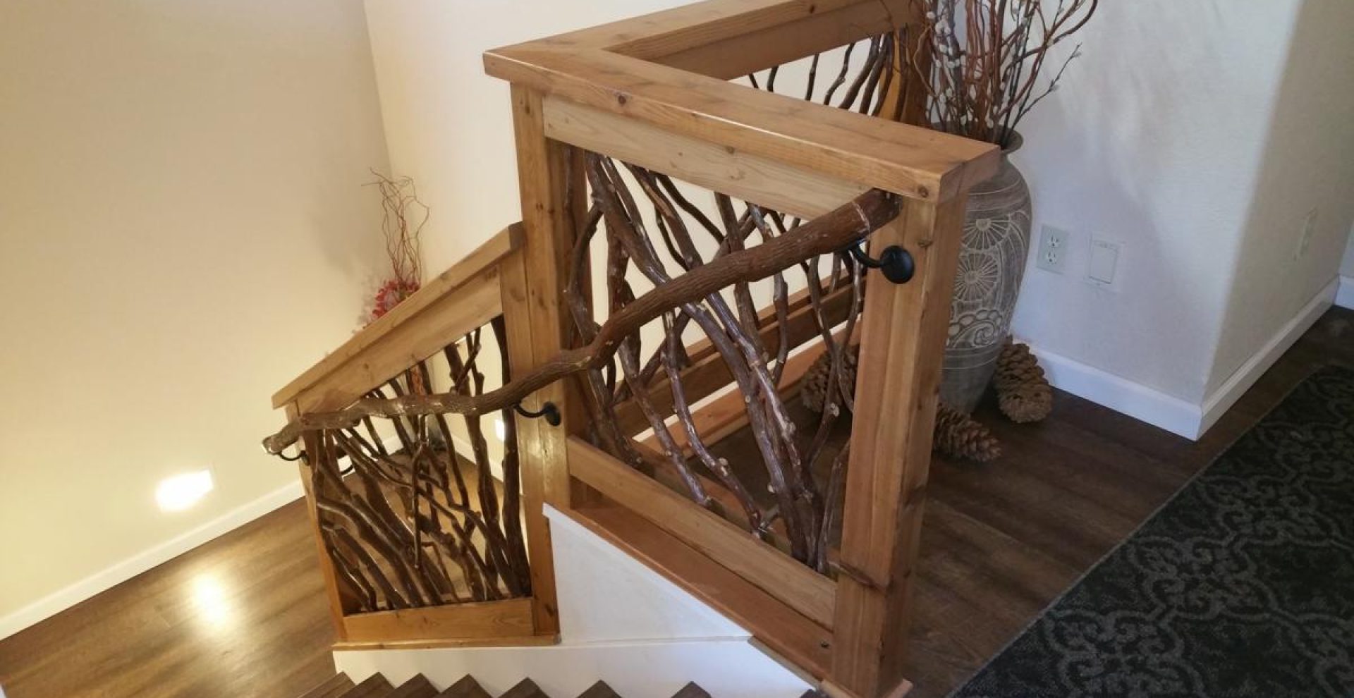 A rustic staircase featuring dark stained laurel branches and a branch banister attached to the Mountain Laurel handrails.