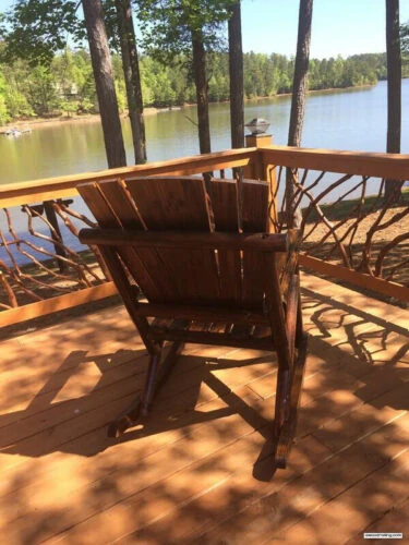 Rustic Adirondack Chair Overlooking Lake And Deck Railing