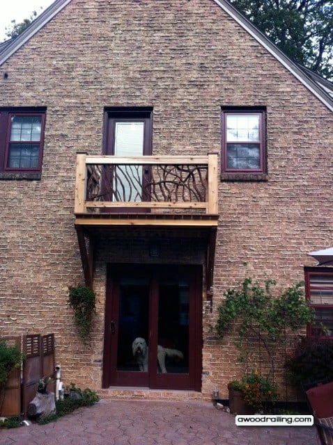 Juliet balcony railing with mountain laurel handrails and a dog visible below