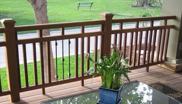 A railing design featuring alternating vertical 2x2s and stock metal balusters below double top plates with short 2x2 connections, ideal for modern deck railing designs.
