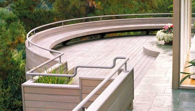 A wood deck bench railing featuring a metal pipe top, designed with increased height for guard rail functionality, seating, and unobstructed views.