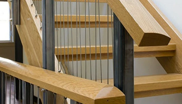 A stair railing design featuring a continuous squiggle pattern with cable railings running up and down from alternating points, ideal for innovative deck railing designs.