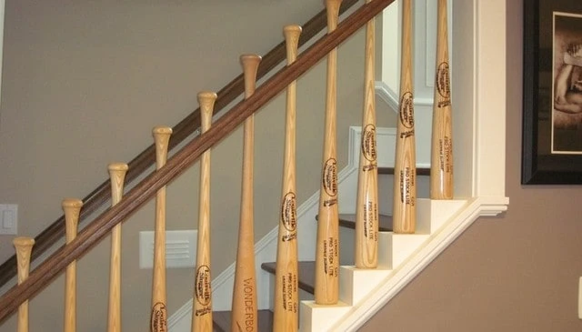 A unique stair railing design showcasing baseball bat balusters with a matching kneewall step-up, exemplifying a cohesive look in outdoor design.