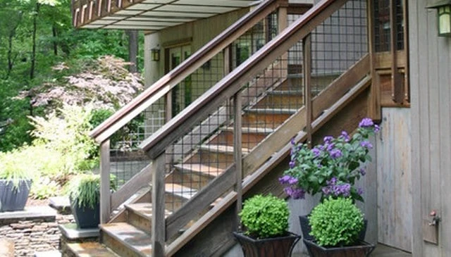 A deck stairs railing design showcasing a 2x6 bottom rail with 4x4 chicken wire infill, with the option to place directly on a small kneewall, exemplifying practical outdoor solutions.
