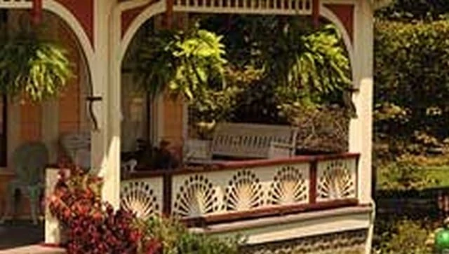 A circular fan porch railing showcasing jigsaw cut teardrops and circles in a variation of the sunburst pattern, exemplifying creative outdoor aesthetics.