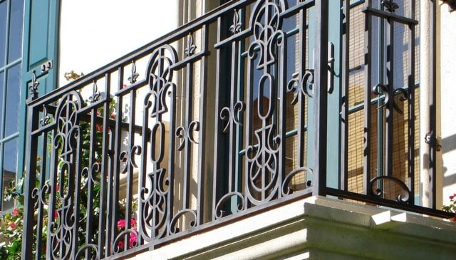 Colonial Mediterranean wrought iron railing showcasing stylized arrows and fleur-de-lys, creating a trident-like appearance exemplifying classic outdoor aesthetics.