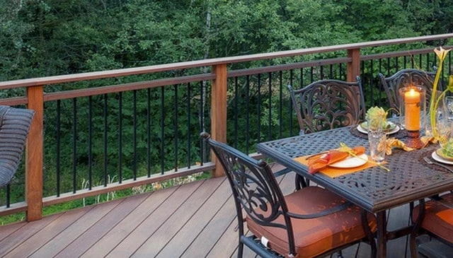 A comfortable outdoor living space showcasing stained wood decking and railing with stock metal balusters and a continuous wood top rail exemplifying inviting outdoor design.