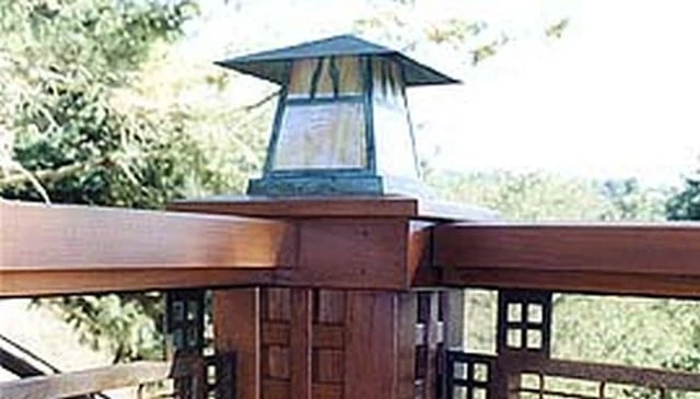 Craftsman style porch design showcasing a small grid motif and lantern-capped posts that provide unique architectural details exemplifying charming outdoor aesthetics.