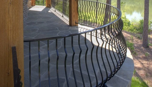 A curved metal railing design showcasing pregnant balusters with profiles resembling a pregnant woman, exemplifying a unique aesthetic in outdoor design.