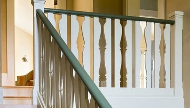 A trompe l’oeil handrail design showcasing cut balusters that create the illusion of turned balusters alongside 2x2 pickets exemplifying innovative deck railing designs.