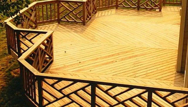 A simple deck design showcasing a combination of vertical picket style and diagonal Chippendale elements, ideal for expansive uncovered decks exemplifying practical outdoor solutions.