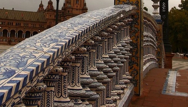 Ornate stone balusters on bridge railing showcasing decorative patterns with special tile treatment on posts exemplifying sophisticated deck railing designs.