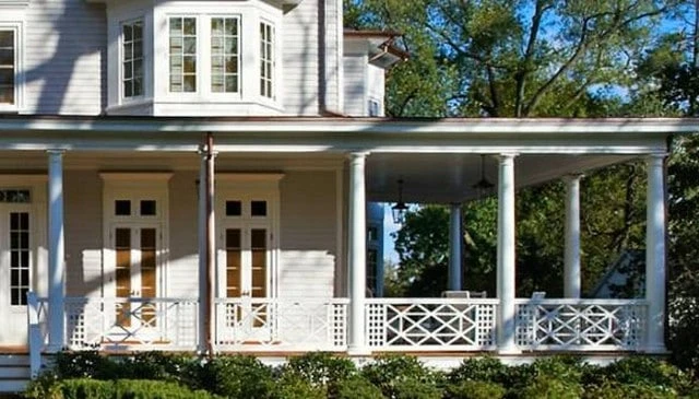 A wood porch railing design showcasing multiple Xs in a 2x3 grid with a central Chippendale element and flanking lattice exemplifying classic deck railing designs.