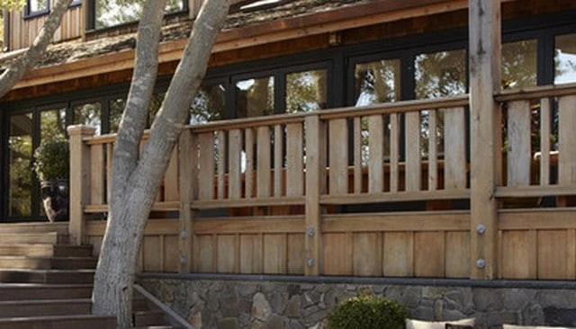A distinctive railing design showcasing alternating vertical boards with varying widths that create a captivating visual rhythm exemplifying innovative deck railing designs.