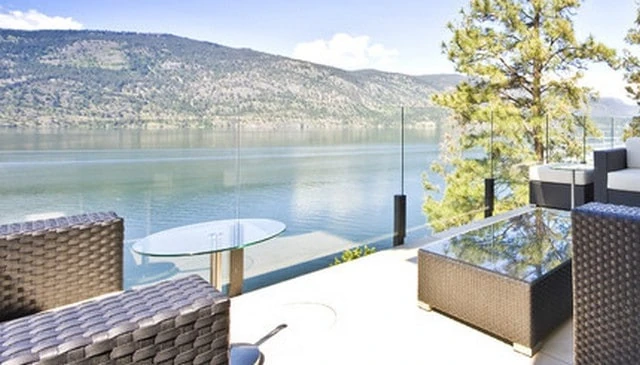 A frameless glass railing showcasing a modern minimalist design that enhances natural light and provides uninterrupted views exemplifying contemporary deck railing designs.