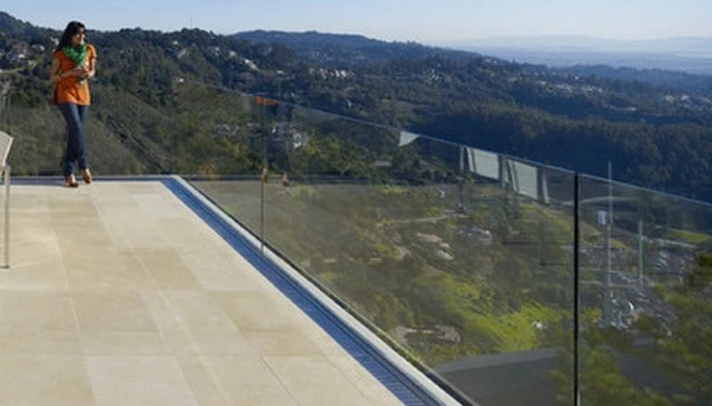 Suspended glass panels showcasing an invisible railing design that enhances a modernist porch with a minimalist aesthetic exemplifying cutting-edge deck railing designs.