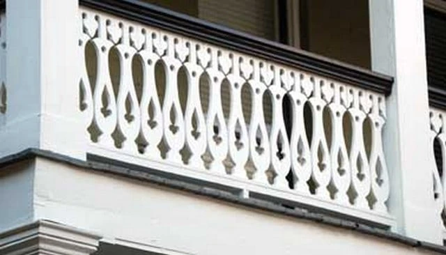 An intricate colonial style sawn baluster guardrail showcasing exclamation points, crosses, and fleur-de-lys motifs, enhancing the elegance of outdoor spaces.