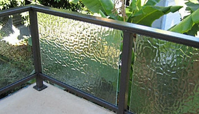 A textured glass railing design that enhances light and view while providing aesthetic appeal, offering less privacy compared to frosted glass.