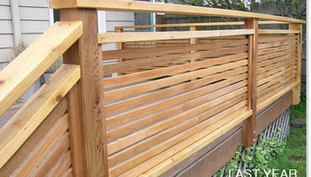 A contemporary wood privacy handrail design with horizontal 1x4 boards topped with a substantial 2x6 cap rail, combining style and functionality for outdoor spaces.