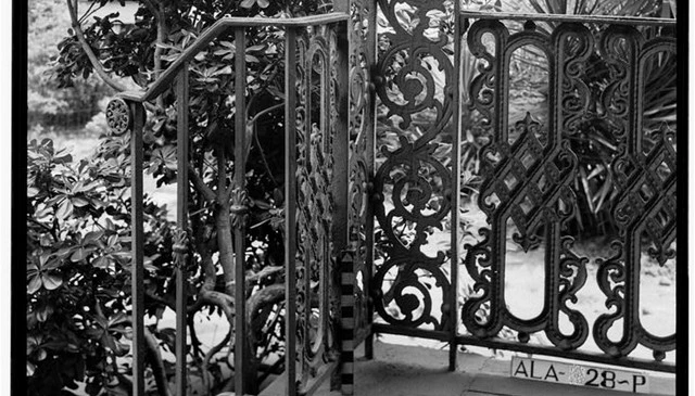 A historic wrought iron railing showcasing ornate patterns and sturdy metal posts, highlighting exceptional craftsmanship and timeless design.