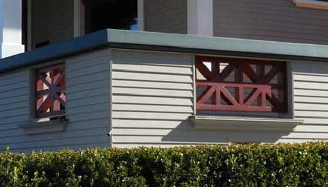 A solid wall railing featuring Chippendale double star inserts, designed to enhance light and breeze for a cool summer front porch experience.