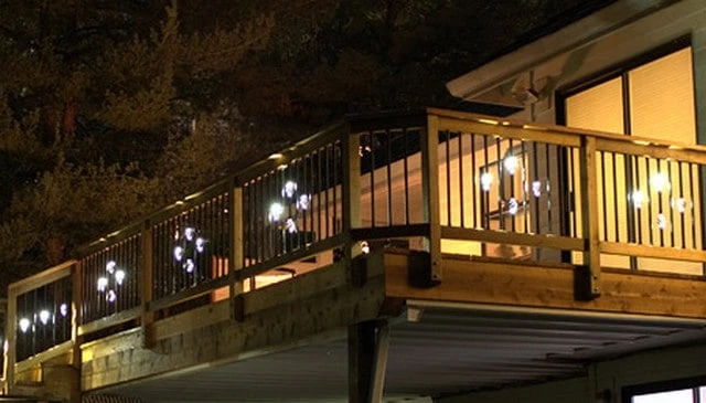 A stylish railing design featuring metal balusters with hidden LED lights, creating stunning evening displays and offering versatile style options for innovative deck railing designs.