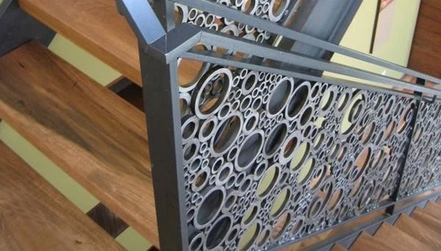 A modern railing design showcasing randomly arranged circles of varying diameters, evoking the appearance of foam or soap bubbles in innovative deck railing designs.