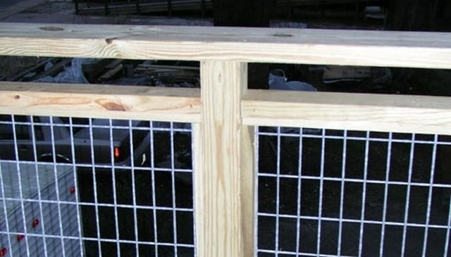 A galvanized metal 2x4 fencing design framed with pressure treated 2x4s and featuring a continuous top rail over sturdy 4x4 posts, showcasing innovative deck railing designs.