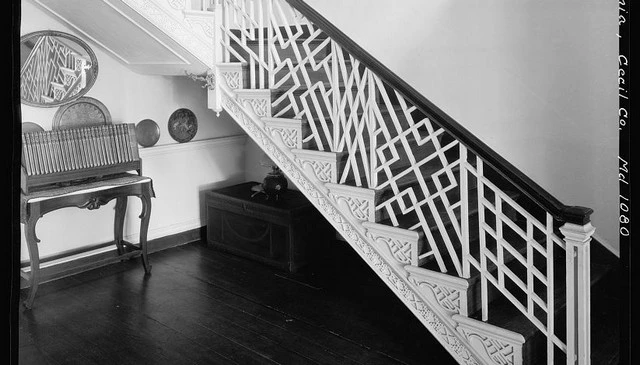 A custom stair railing featuring intricate multiple pattern sections in a classic Chippendale design, ideal for showcasing unique deck railing designs in mountain home renovations.