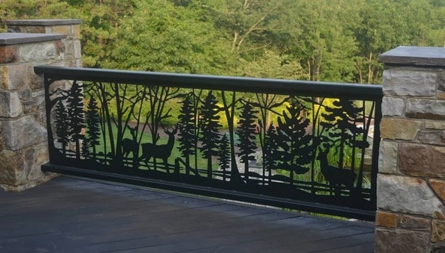 A creative deck railing design featuring nature rails and a metal slab carved out to depict a forest scene with animals