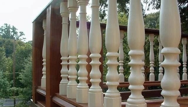 A distinctive deck railing design featuring ornate turned balusters with octagon bases and caps, showcasing multiple curves and flutes