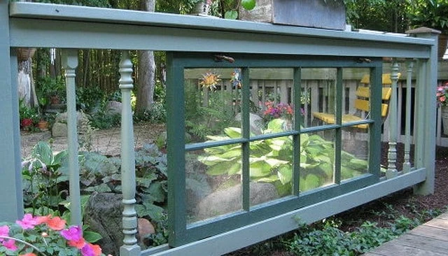 A charming repurposed door railing design featuring upcycled materials and turned balusters, creating a delightful counterpoint for outdoor gardens