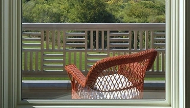 A stylish deck railing design featuring diagonal wood panel handrails arranged in a 16-inch grid formation, combining safety and artistic flair