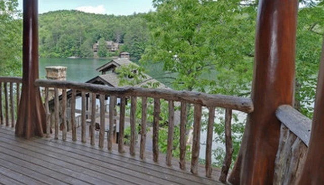 Log handrail design overlooking Lake Rabun, Georgia, featuring a 4-inch diameter top rail with log posts and balusters for rustic deck railing design.