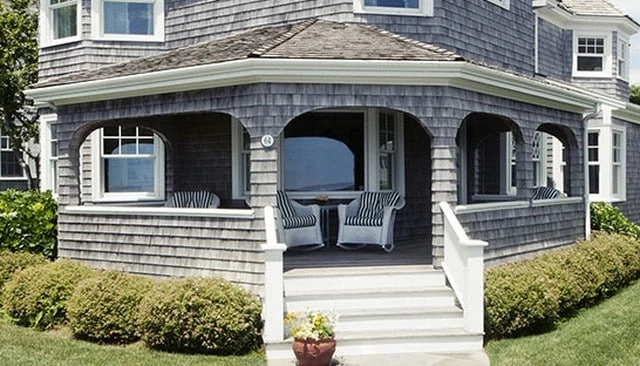 Solid knee wall deck design featuring seamless integration with weathered cedar shingles for a cohesive outdoor look in deck railing design.
