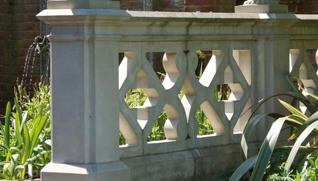 Garden parapet design featuring modified X shapes, adorned with an ornate multi-profile top cap and post finials for decorative deck railing design.