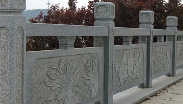 Gorgeous outdoor railing design featuring a solid granite guardrail adorned with various intricate carvings for unique deck railing design.
