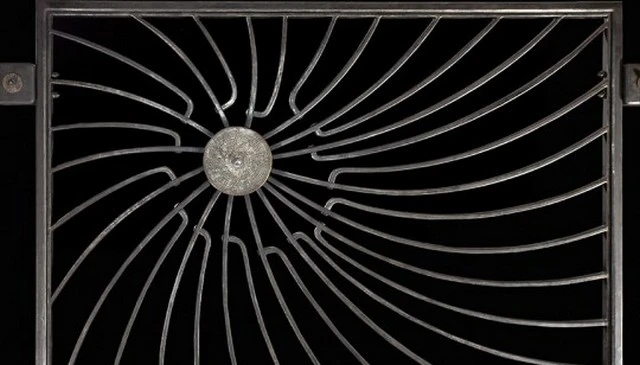 Unique sunburst design featuring an off-center metal disk with spiraling nautilus-inspired metal pieces transitioning to metal railing ideas.