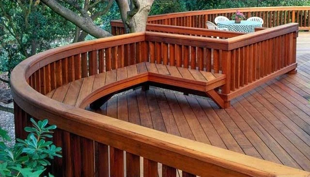 A deck bench featuring a standard handrail with vertical post balusters, providing a classic design for deck railing ideas.