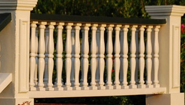 Colonial style brick porch featuring wood trimmed posts and classic turned balusters, beautifully illuminated by early morning sunlight.